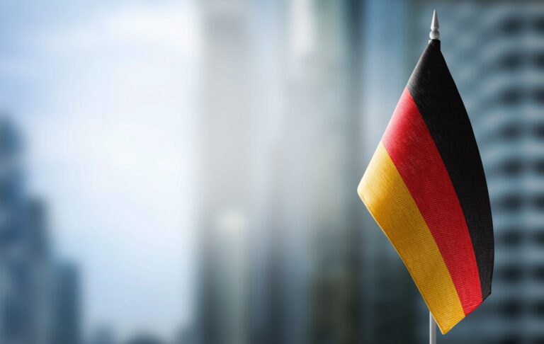 flaga niemiecka na tle nowoczesnych biurowców strategie nauki języka niemieckiego Preston Publishing