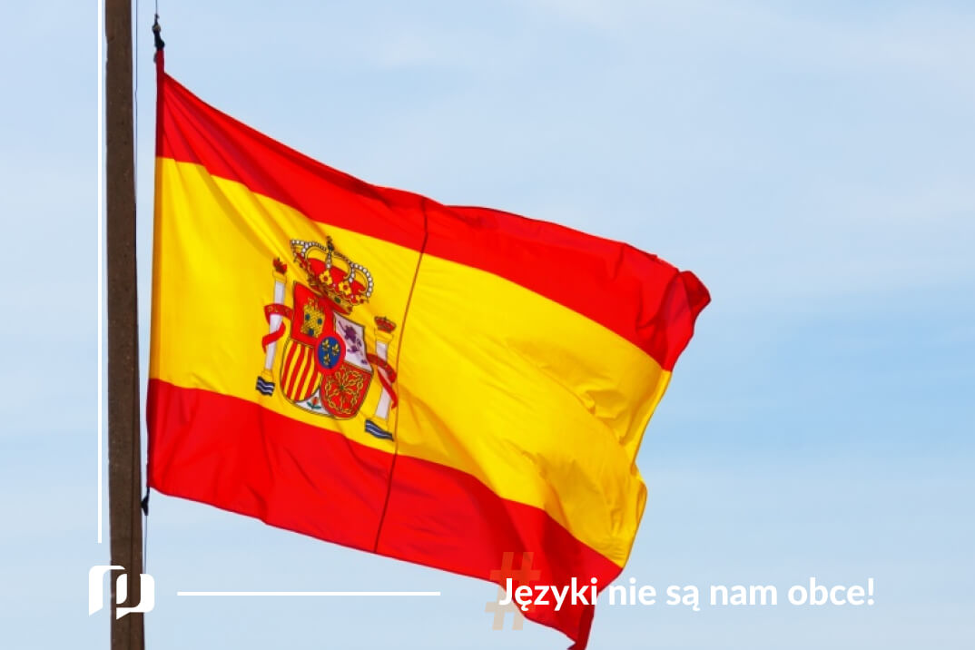 flaga Hiszpanii na tle niebieskiego nieba Fiesta Nacional de España, czyli Dzień Hiszpanii Hiszpańskie tradycje i zwyczaje Preston Publishing