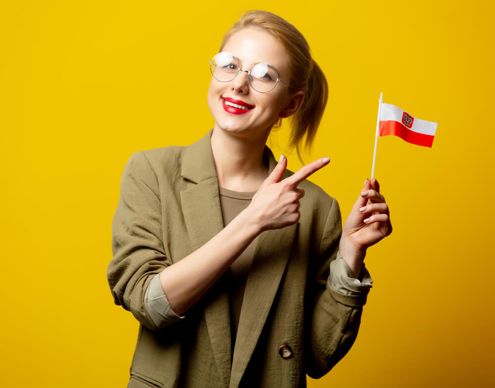 uśmiechnięta dziewczyna w okularach trzyma małą flagę Polski na patyczku Польська мова для українців Preston Publishing