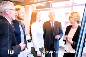 kilka elegancko ubranych osób w biurze lub na szkoleniu prowadzi ożywioną dyskusje spotkanie biznesowe język francuski Preston Publishing