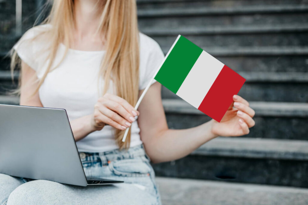 kobieta z włoską flagą siedząca przed komputerem nauka języka włoskiego Preston Publishing