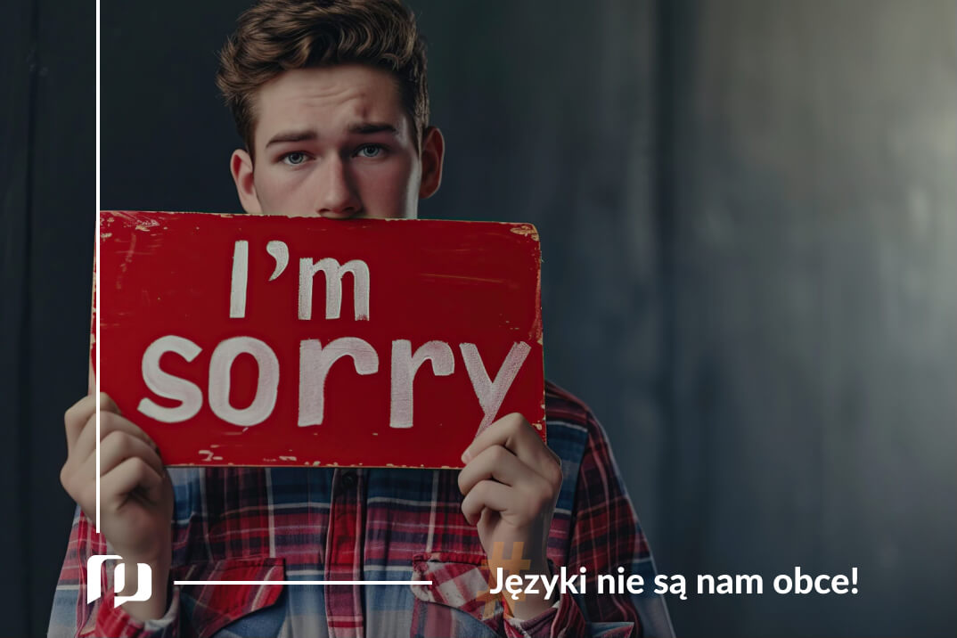 mężczyzna w kraciastej koszuli stojący na tle ciemnej ściany trzymający w rekach tabliczkę zasłaniająca mu polowe twarzy oprócz oczu z napisem przepraszam po angielsku nauka angielskiego Preston Publishing