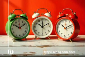 na drewnianym białym stole stoja trzy budziki w kolorach włoskiej flagi: zielonym, białym i czerwonym, zadawanie pytań o godzinę po włosku nauka języków z Preston Publishing