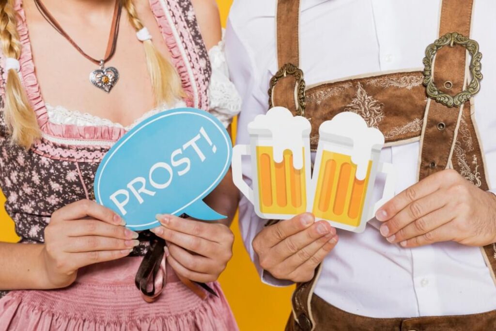 para ubrana w tradycyjne niemieckie stroje trzyma papierowe kufle z piwem oraz dymem z napisem prost czyli na zdrowie przy wznoszeniu toastu podstawowe zwroty po niemiecku Preston Publishing