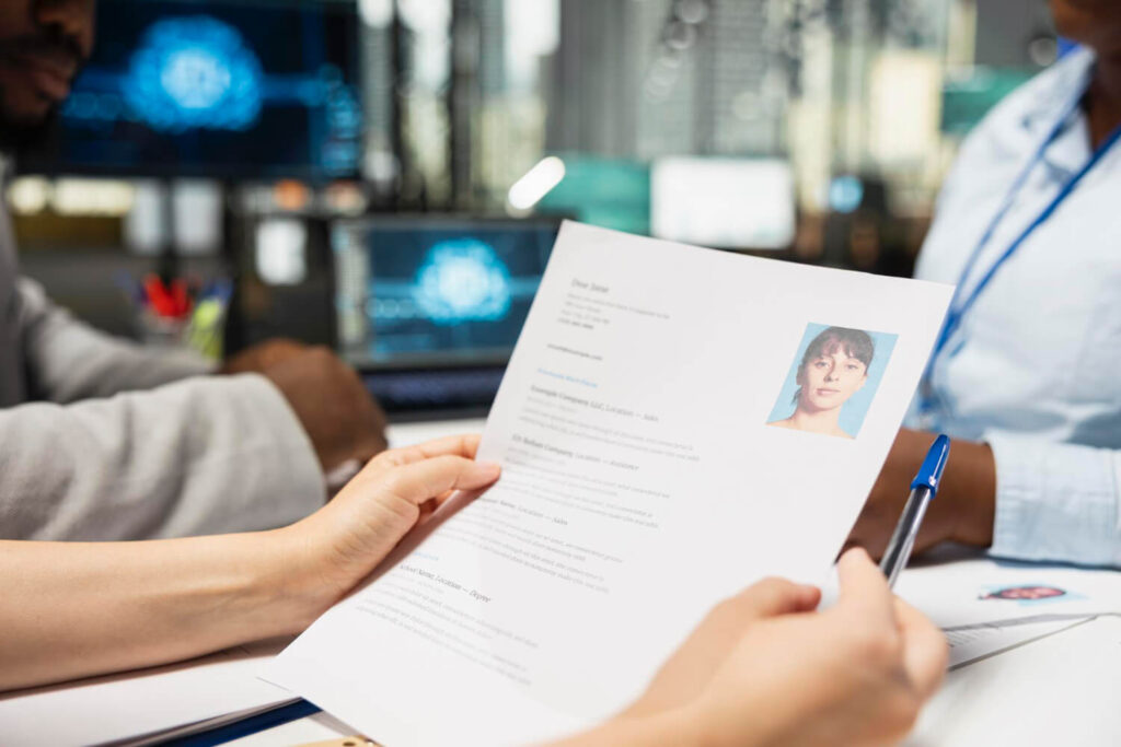 osoba siedząca przy biurku oglądająca cv jak napisać cv po francusku Preston Publishing
