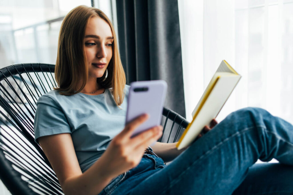 dziewczyna czytająca książkę i odbierająca telefon nauka angielskich czasów czas przeszły Past continuous jak go używać Preston Publishing