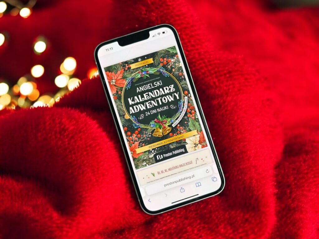 okładka ebooka Angielski kalendarz adwentowy od Preston Publishing wyświetlona na telefonie a w tle czerwony ciepły zimowy kocyk