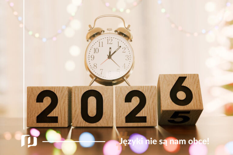 drewniane klocki z napisem 2026 oraz budzik z wybijająca północą noworoczne postanowienia językowe z Preston Publishing