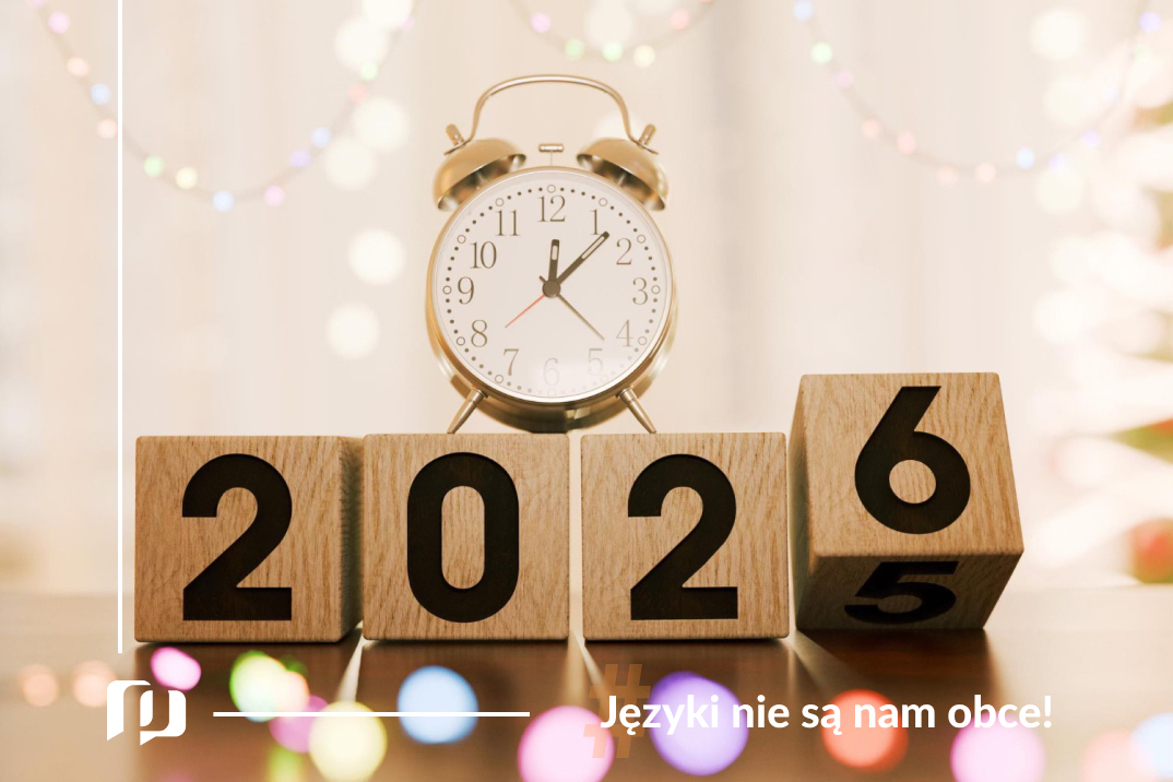 drewniane klocki z napisem 2026 oraz budzik z wybijająca północą noworoczne postanowienia językowe z Preston Publishing