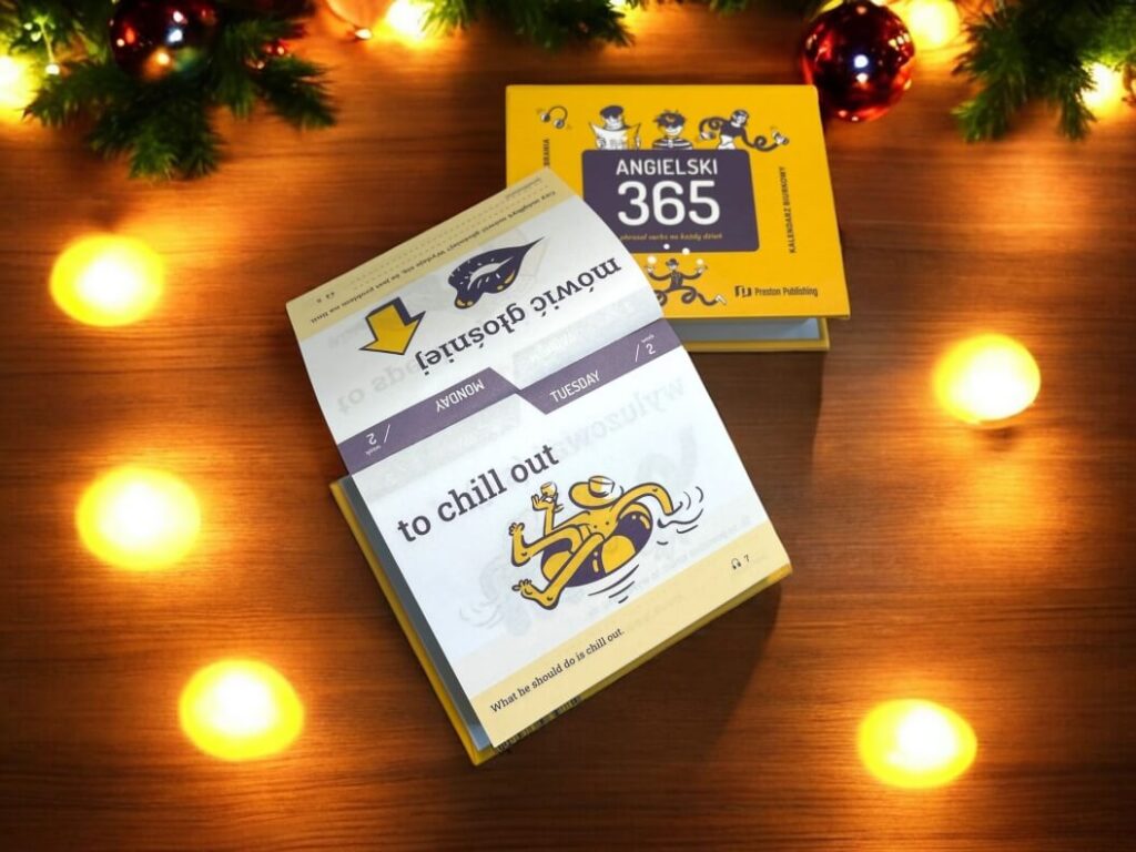 kalendarz biurkowy z phrasalami na każdy dzień roku do nauki heeyka angielskiego na świątecznym tle lampek i gałązek