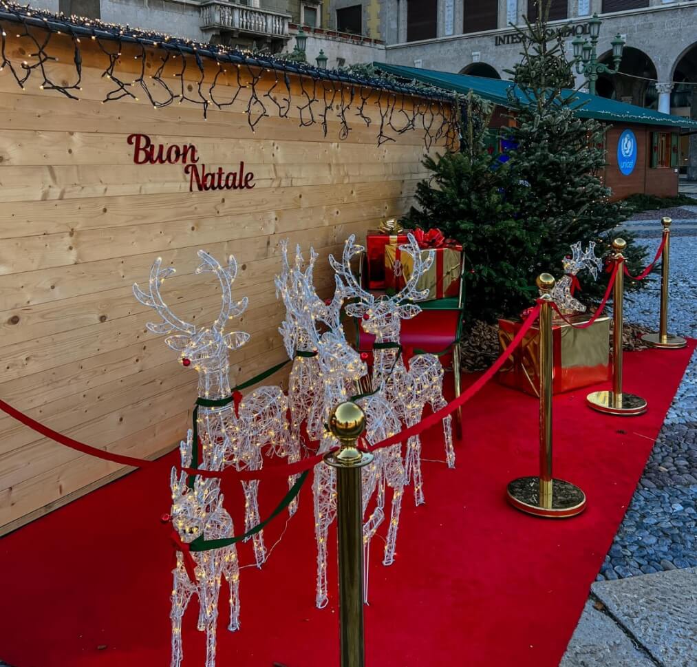 świąteczna dekoracja z reniferami i saniami na rynku włoskiego miasteczka nauka świątecznych zwrotów po włosku z Preston Publishing