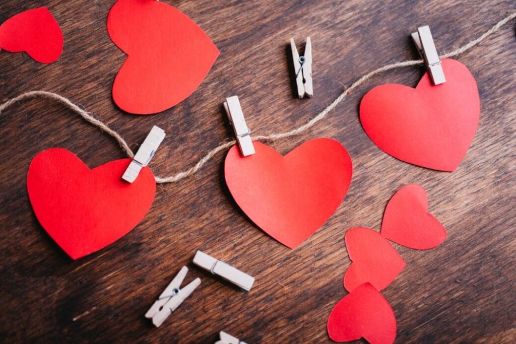 serduszka zawieszone na sznurku i przyczepione spinaczami na brązowym tle nauka języków obcych i słownictwa z Preston Publishing