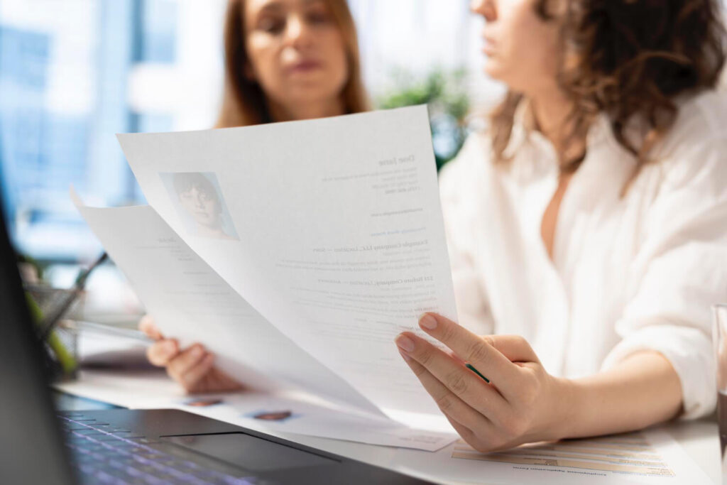 dwie osoby przeglądają aplikacje kandydatów do pracy cv i listy motywacyjne po francusku z Preston Publishing