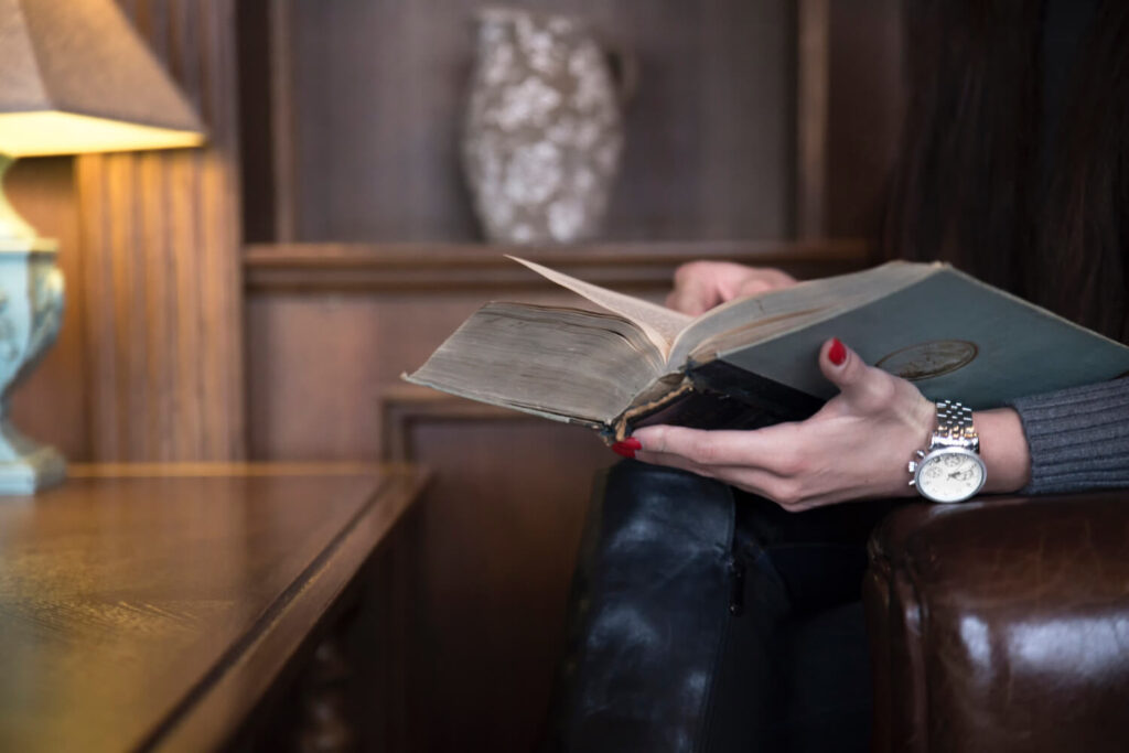 kobieta siedząca w fotelu i czytająca stara książek w języku francuskim czas przeszły Preston Publishing