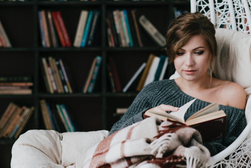 kobieta czytająca książkę po angielsku zaciekawiona lektura  od Preston Publishing