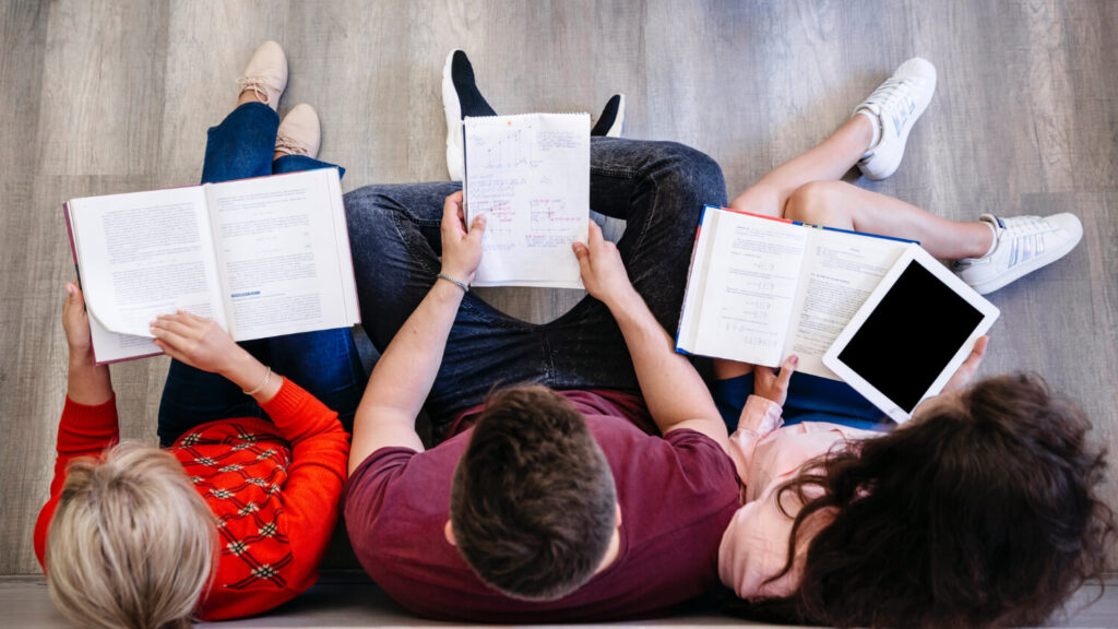 kilka osób widzianych z góry czytających książki nauka języka przez czytanie Preston Publishing