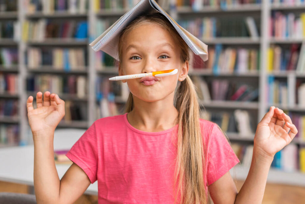 dziewczynka ucząca się włoskiego z książka na głowie i ołówkiem zamiast wąsów nauka włoskiego dla dzieci przez zabawę z Preston Publishing