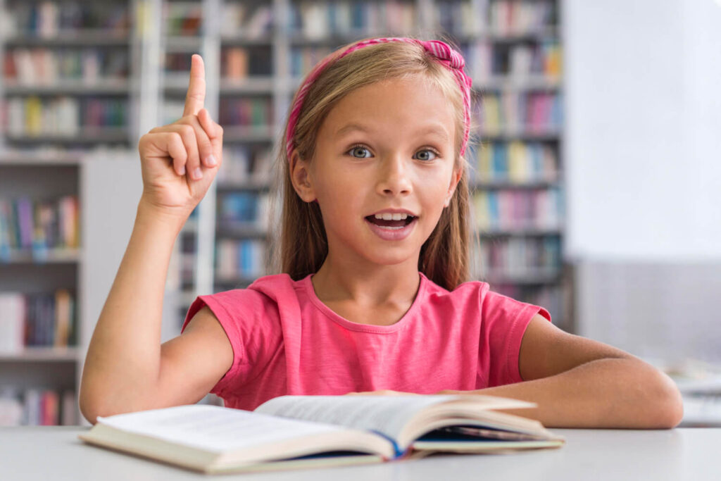 dziewczynka ucząca się włoskiego z ręką uniesiona w gore jakby się zgłaszała do odpowiedzi nauka włoskiego dla dzieci przez zabawę z Preston Publishing