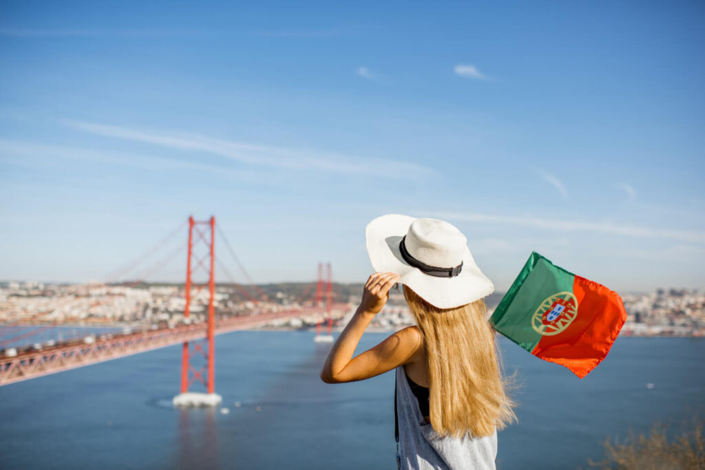 dziewczyna z flaga portugalska patrzaca melancholijnie w dal na portugalski krajobraz saudade znaczenie nauka jezyka portugalskiego Preston Publishing