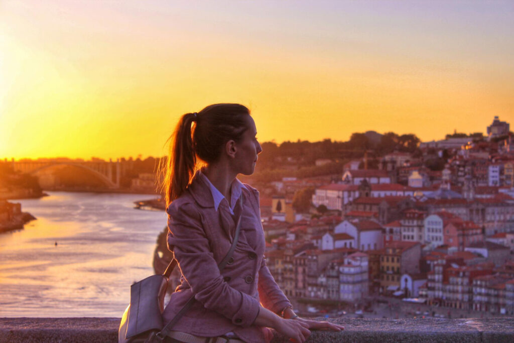 dziewczyna siedzaca na klifie patrzacya melancholijnie w dal na portugalski krajobraz saudade znaczenie nauka jezyka portugalskiego Preston Publishing